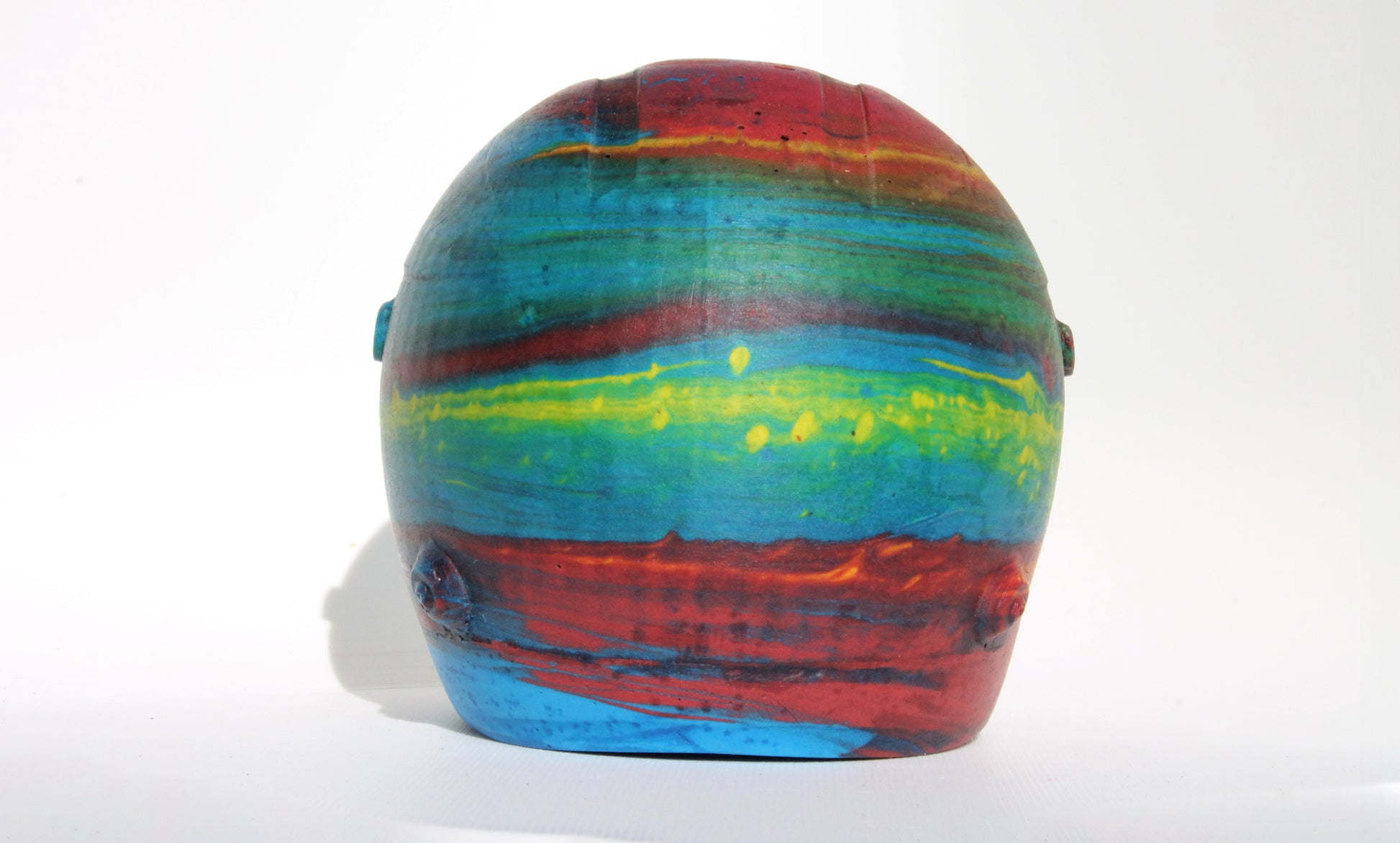 Back angle of Custom-made concrete mini Formula 1 helmet designed with vibrant red, blue, and yellow colors, resembling a galaxy theme. The helmet, crafted from concrete/Jesmonite, showcases intricate details and a glossy finish, reflecting the cosmos. Available for purchase with customization options on the website.