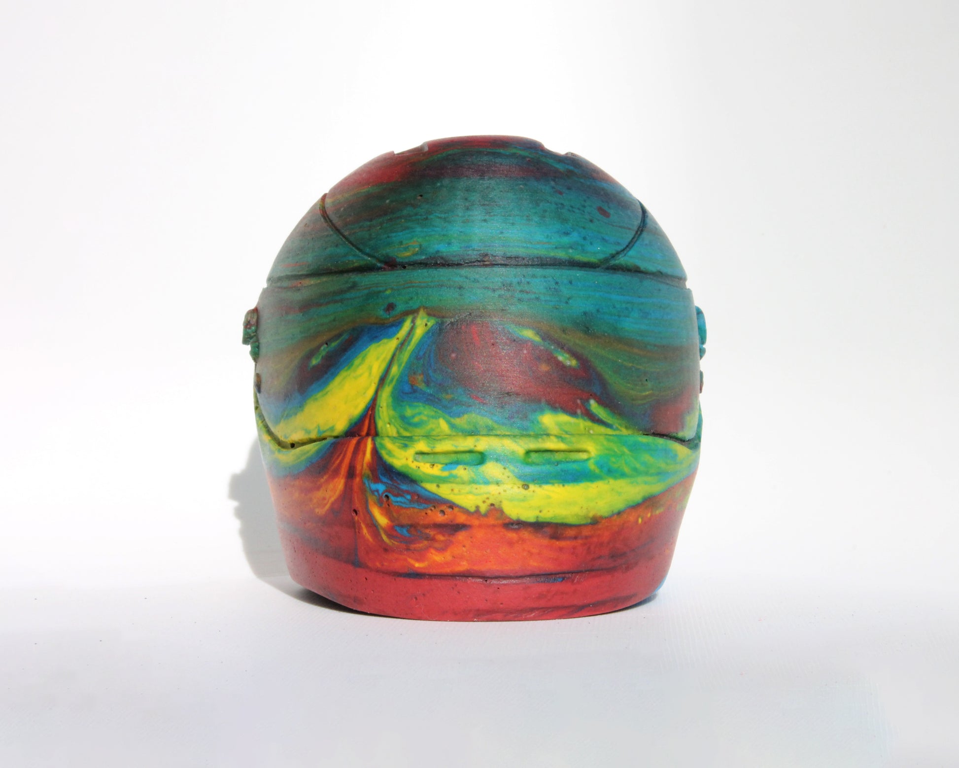 Front straight  angle of Custom-made concrete mini Formula 1 helmet designed with vibrant red, blue, and yellow colors, resembling a galaxy theme. The helmet, crafted from concrete/Jesmonite, showcases intricate details and a glossy finish, reflecting the cosmos. Available for purchase with customization options on the website.